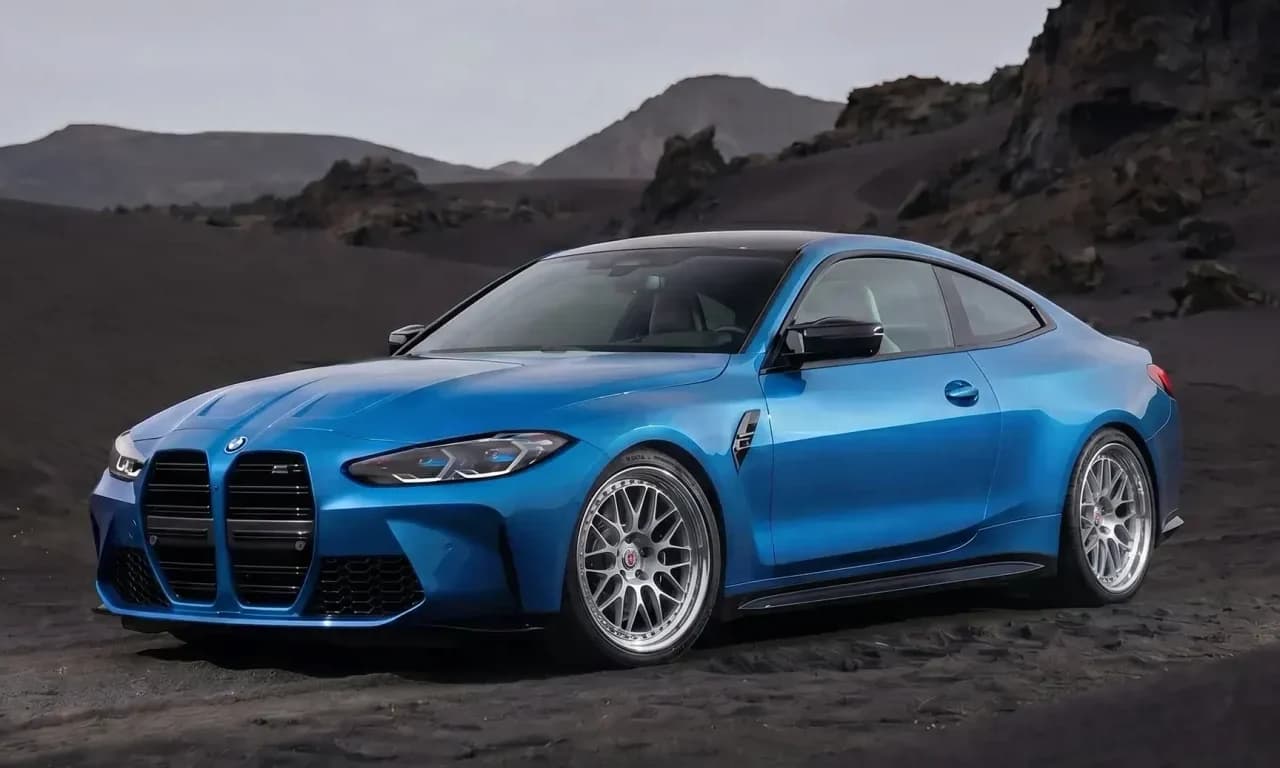 Blue BMW M4 coupe with bright multi-spoke performance wheels on black volcanic sand